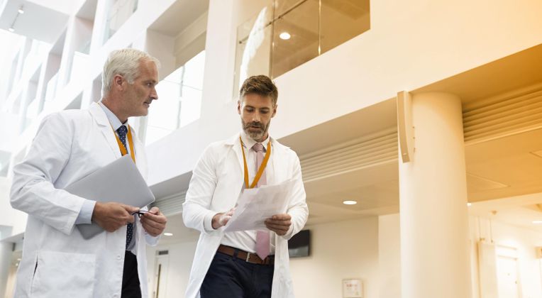 Zwei Ärzte diskutieren im Foyer eines Krankenhauses