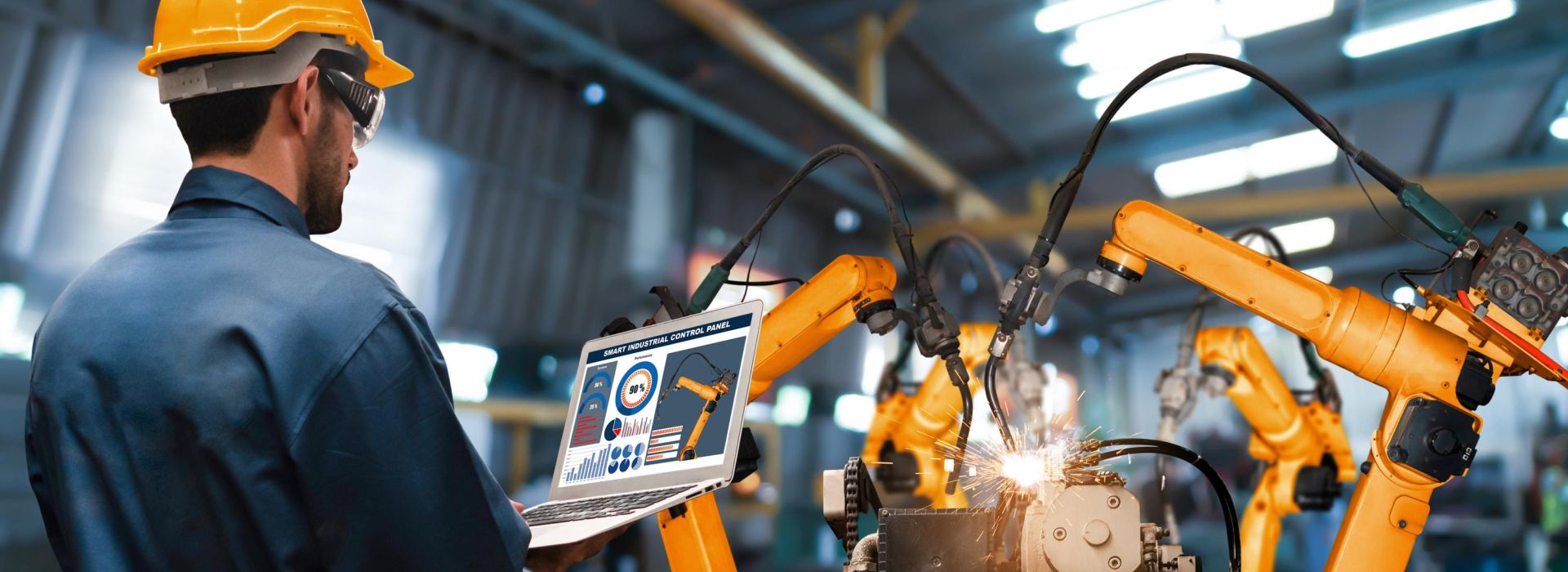 A man works at a tablet and operates a machine that is digitally controlled.