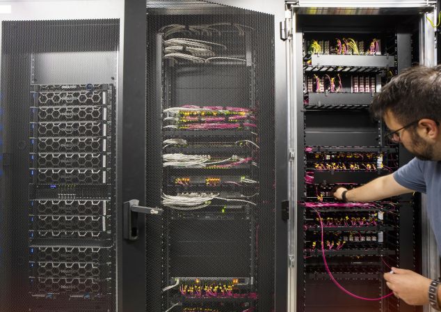 An AKQUINET employee works on a server cabinet in the data center.