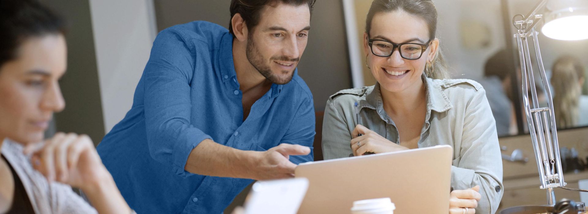 Ein Mann zeigt einer Frau etwas auf einem Notebook.