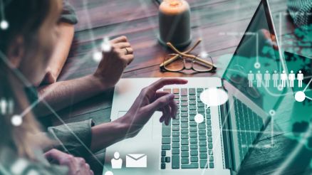 Zwei Personen sitzen vor einem Notebook und besprechen das, was sie auf dem Bildschirm sehen.