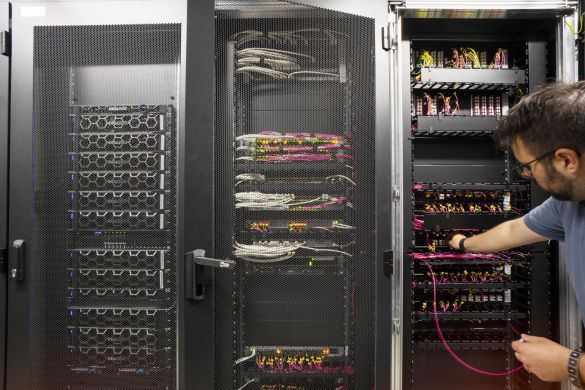 Ein Mitarbeiter der AKQUINET arbeitet an einem Serverschrank im Rechenzentrum.