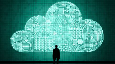 Ein Mann steht vor einer großen digitalen Wand und darauf sieht man eine virtuelle Wolke.