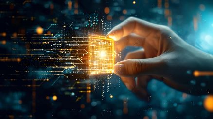 Nahaufnahme einer Hand, die einen leuchtenden, goldfarbenen Mikrochip hält, umgeben von abstrakten digitalen Schaltkreisen auf dunklem Hintergrund.