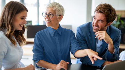 Zwei Frauen und ein Mann diskutieren über Inhalte auf einer Website.