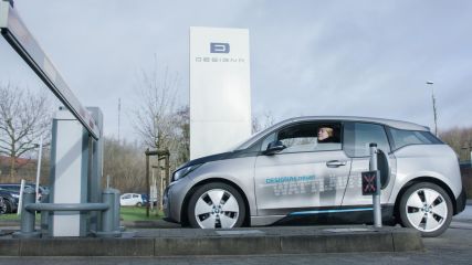 Eine Frau passiert in ihrem Auto eine Schranke zu einem Parkplatz.