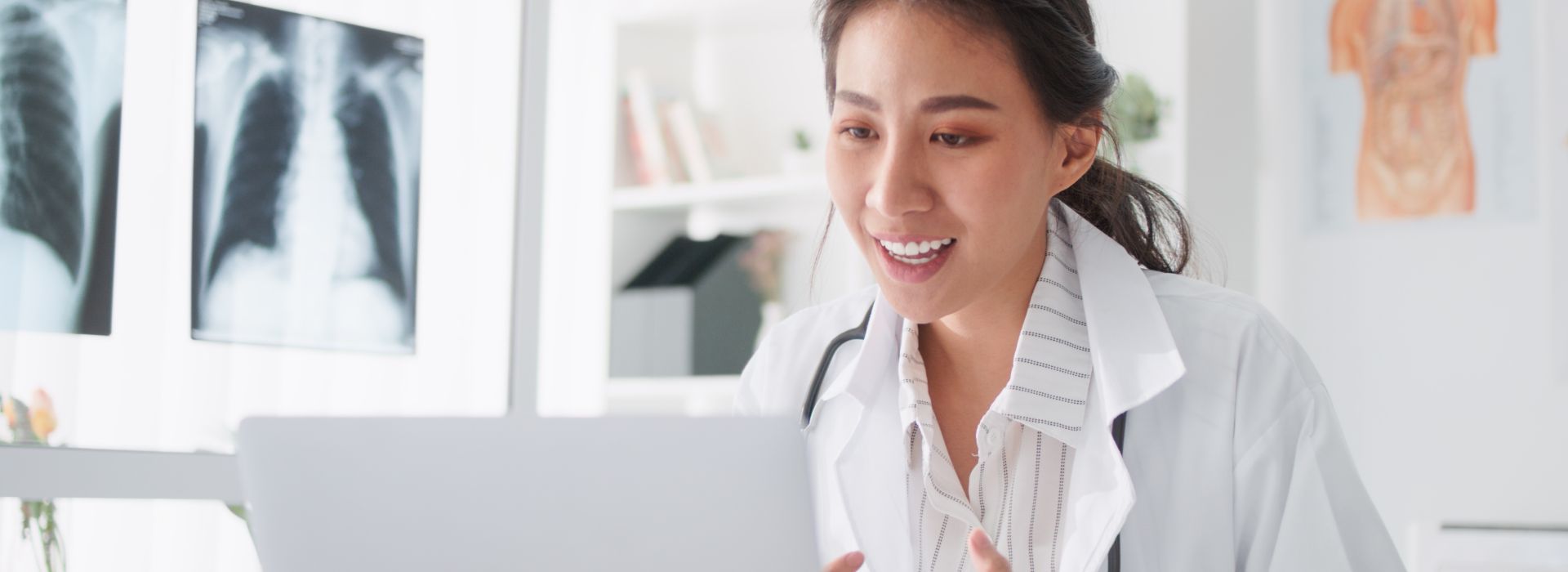 Eine Äztin führt in ihrem Behandlungszimmer eine KBV-zertifizierte Videosprechstunde mit einem Patienten über die Software kvvideo von Akquinet durch.