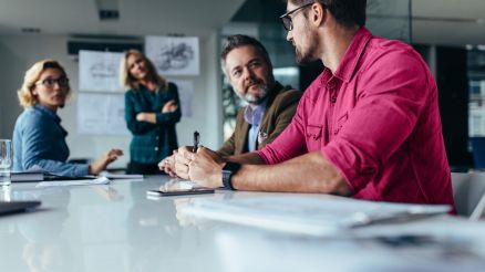 A group of four people sat at a conference table.