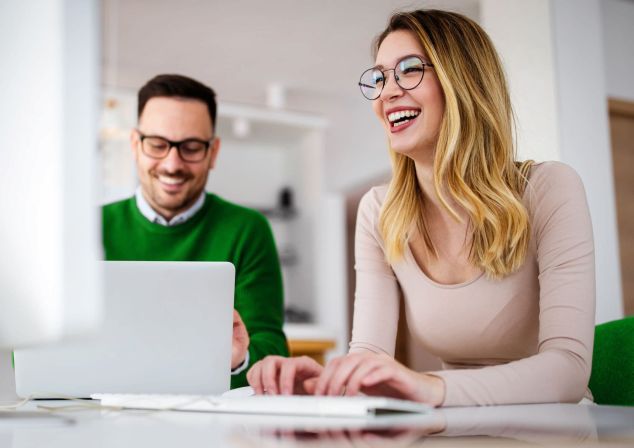 Ein Mann und eine Frau schauen sich Informationen auf einem Notebook an.