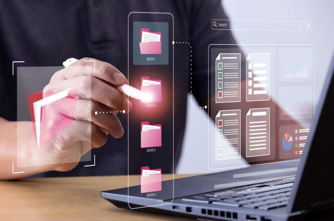 Dateiverwaltung wird imaginär mit Ordner Symbolisiert. Laptop und Hände sind zu sehen.