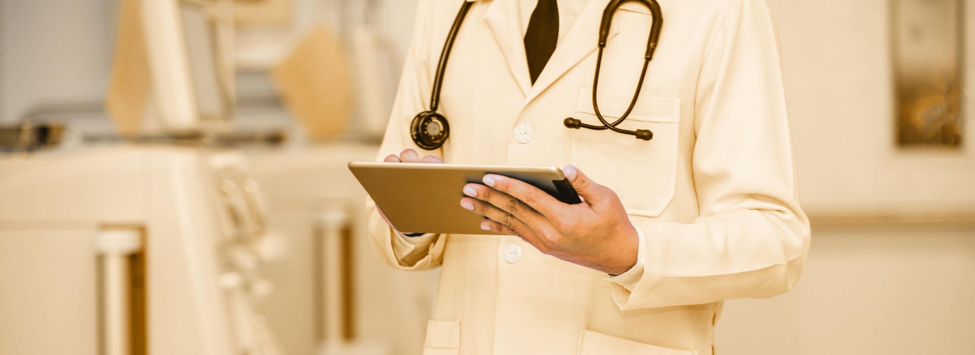 Arzt mit Tablet in der Hand steht vor Geräten zur Blutwäsche