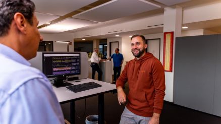 Zwei Mitarbeiter von AKQUINET tauschen sich am Arbeitsplatz aus.