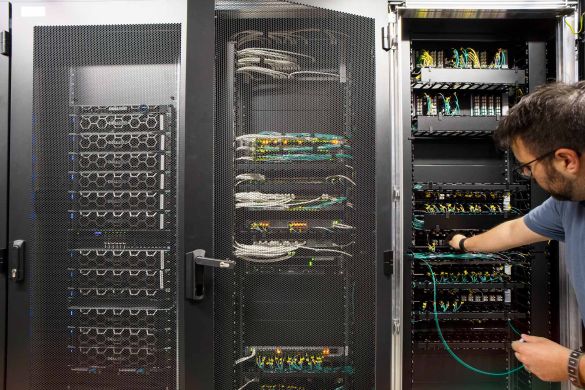 Ein Data Center Mitarbeiter arbeitet am Rack im Systemraum des AKQUINET Rechenzentrums