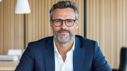 Mann im business Outfit schaut in die Kamera.