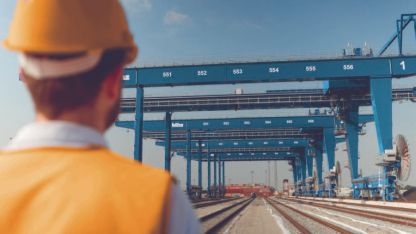 An employee wearing a safety helmet looks at the rail network and container crane systems at the EUROGATE Container Terminal in Bremerhaven. AKQUINET's CHESSCON simulation was used to determine the location of a new rail terminal here