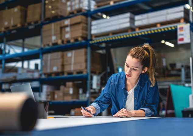 Eine Frau sitzt an einem Arbeitsplatz in der Logistik.