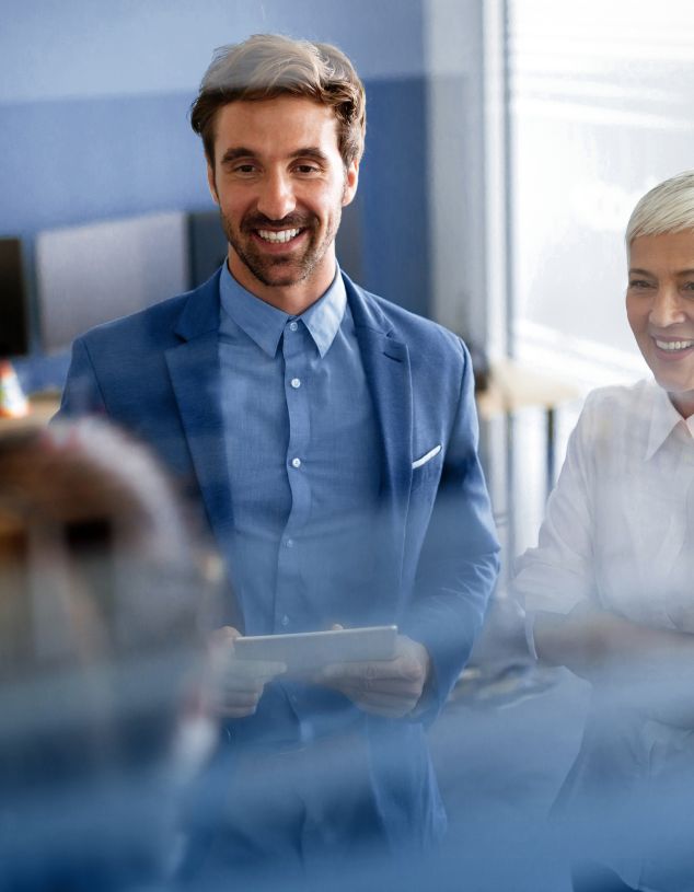 Kunde wird von zwei Microsoft Expert*innen zur Digitalisierung in seinem Vertrieb beraten. Ein Mann überprüft die Costumer Journey im Hintergrund.