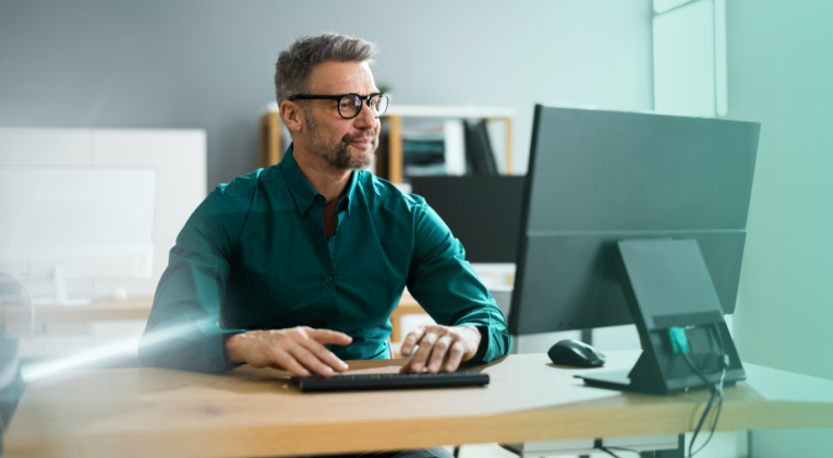 Ein Mann arbeitet mit Microsoft Fabric an seinem Computer, unterstützt von AKQUINET bei der digitalen Transformation. Dabei profitiert er von den Vorteilen von Microsoft Fabric und OneLake.