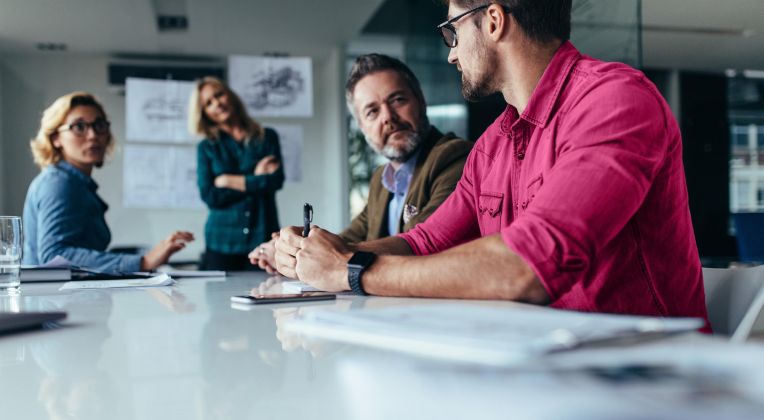 A group of four people sat at a conference table.