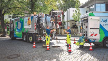 A team from Berliner Wasserbetriebe takes care of a sewer on a street.