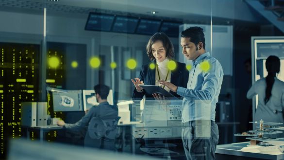 Infor ERP-Cloud-Software von AKQUINET Eine Frau und ein Mann arbeiten im Stehen gemeinsam an einem Tablet Computer