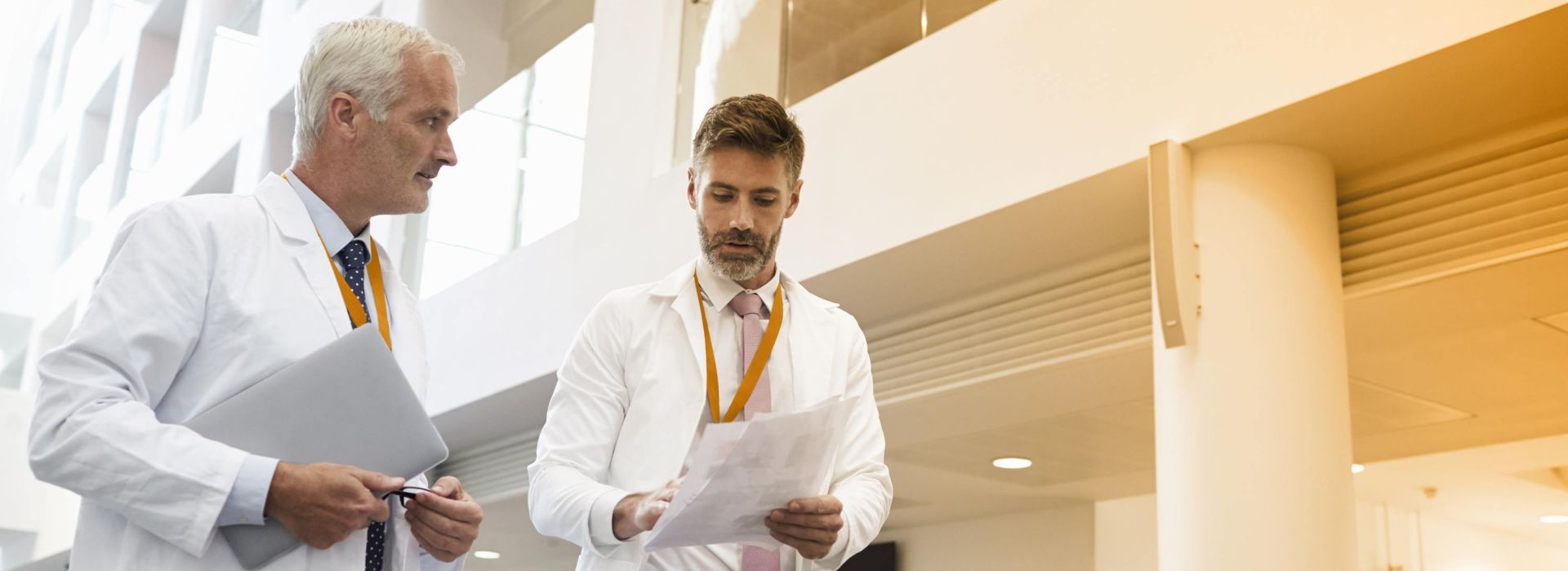 Zwei Ärzte diskutieren im Foyer eines Krankenhauses