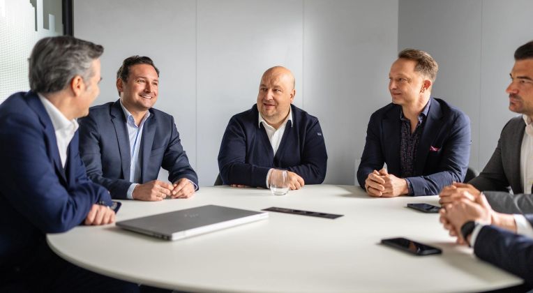 Mehrere Manager der Firma akquinet sitzen am Konferenztisch.