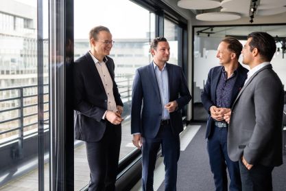 Männer im Anzug stehen in einem Gespräch zusammen.