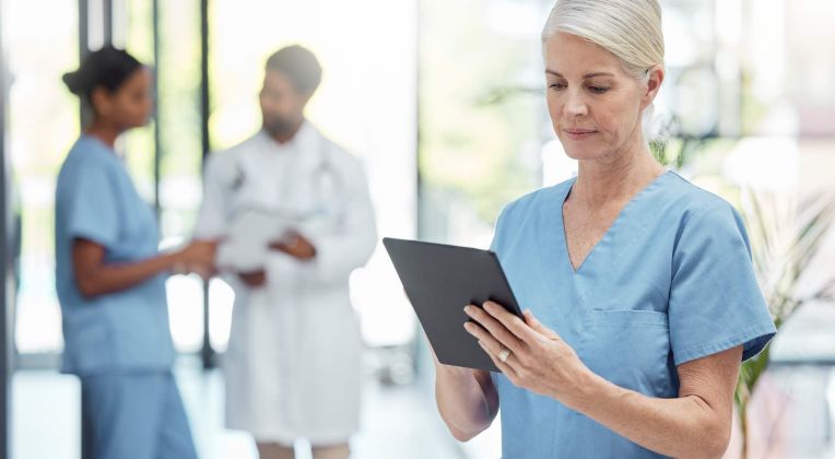 A nurse works with a tablet