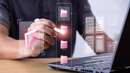 Dateiverwaltung wird imaginär mit Ordner Symbolisiert. Laptop und Hände sind zu sehen.
