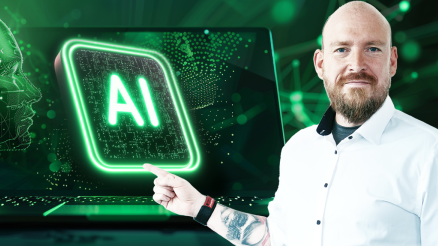 Unser KI Experte Marcus Wuest zeigt auf ein schwebendes „AI“-Symbol – dies symbolisiert die Verbindung von Mensch und Künstlicher Intelligenz sowie den Fortschritt in der Technologie.