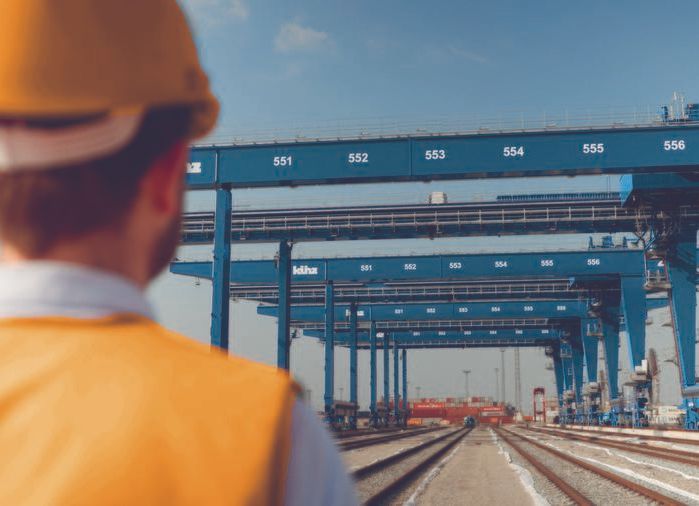 An employee wearing a safety helmet looks at the rail network and container crane systems at the EUROGATE Container Terminal in Bremerhaven. AKQUINET's CHESSCON simulation was used to determine the location of a new rail terminal here