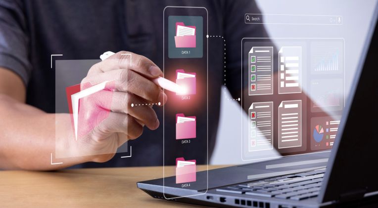 Dateiverwaltung wird imaginär mit Ordner Symbolisiert. Laptop und Hände sind zu sehen.