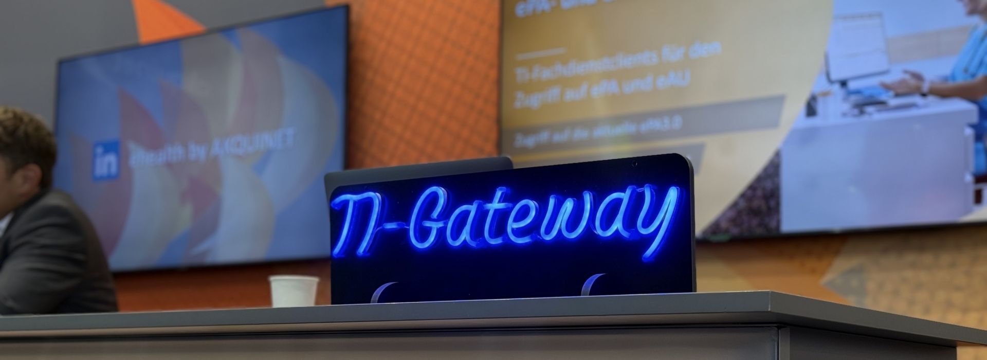 Tresen mit blau leuchtendem Logo TI-Gateway