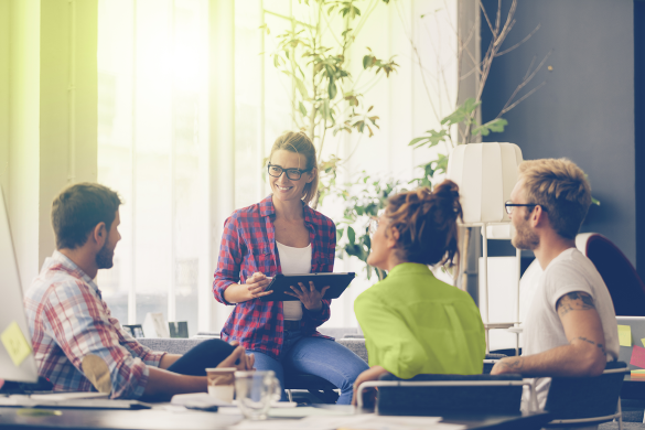 Eine Mitarbeitende sitzt mit drei Kunden im AKQUINET-Büro und berät zum richtigen Umgang mit Unternehmensdaten.