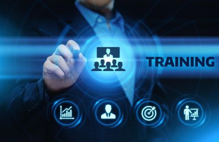 Geschäftsperson tippt auf ein digitales Interface mit Symbolen für Wachstum, Zielerreichung, Personal und Präsentation; in der Mitte das Wort „TRAINING“.