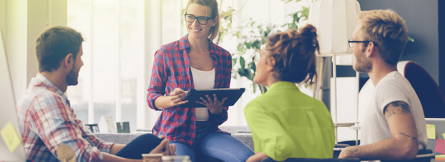Eine Mitarbeitende sitzt mit drei Kunden im AKQUINET-Büro und berät zum richtigen Umgang mit Unternehmensdaten.