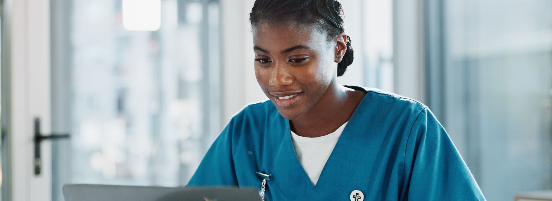 Eine junge Ärztin arbeitet an einem Laptop mit der ePA von AKQUINET