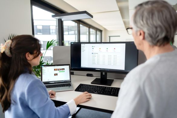 Mitarbeitende von AKQUINET tauschen sich im Büro aus.