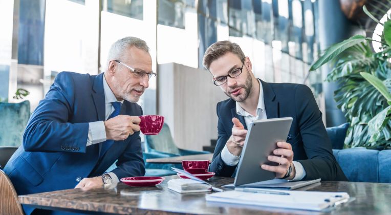 Zwei Männer, einer jünger und einer etwas älter sitzen zu einem Beratungsgespräch zusammen.