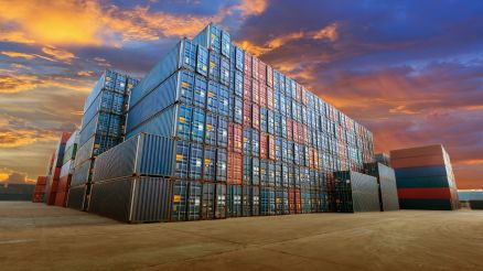 Bunter Containerstapel auf grauen Betonplatten.