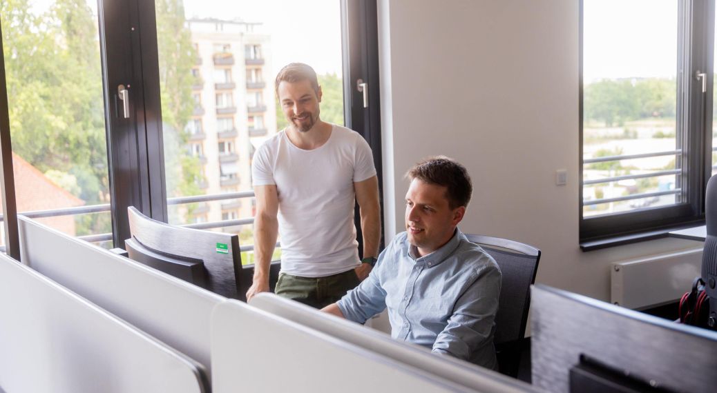 AKQUINET employees in a meeting in front of a computer.