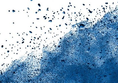 Feiner blauer Staub auf weißem Hintergrund, ähnlich wie beim Farbfest Holi.