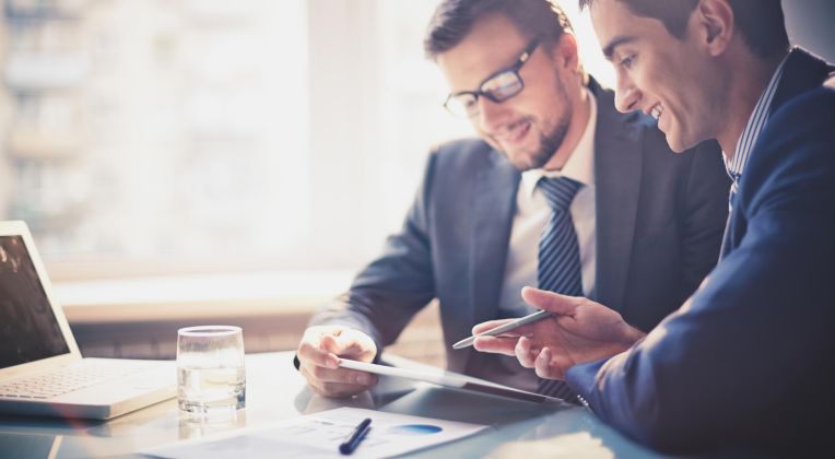 Zwei Personen sitzen an einem Tisch und sprechen.