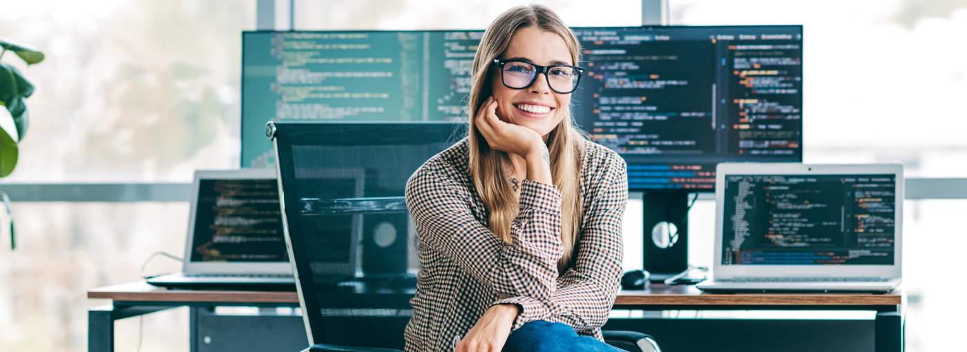 Eine junge Programmiererin sitzt am Schreibtisch