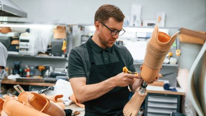 Ein junger Orthopädietechniker baut eine Beinprothese