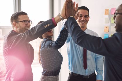 Vier Personen klatschen sich ab.
