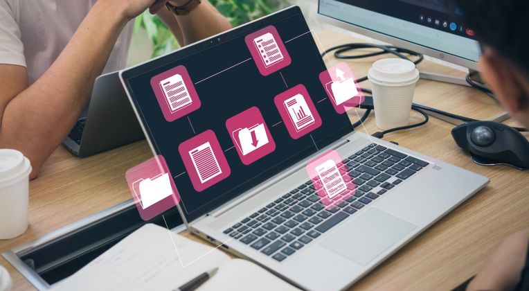 Ein Foto auf dem Ein aufgeklappter Laptop zu sehen ist, auf dem Ordner geöffnet sind.