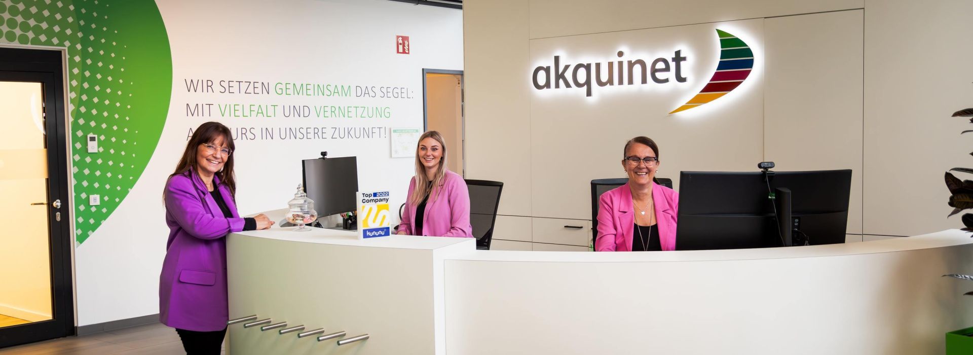 Drei Mitarbeiterinnen vom Office Managements am Empfang des AKQUINET Hauses in Hamburg Bramfeld.