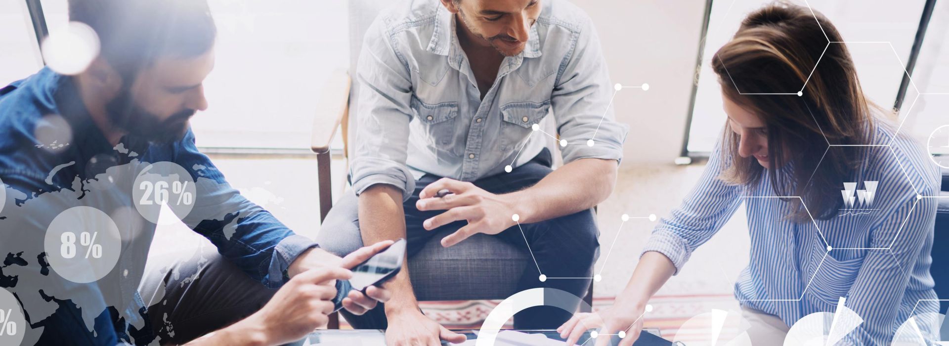 Zwei Männer und eine Frau schauen sich Informationen auf einem Notebook und Handy an.